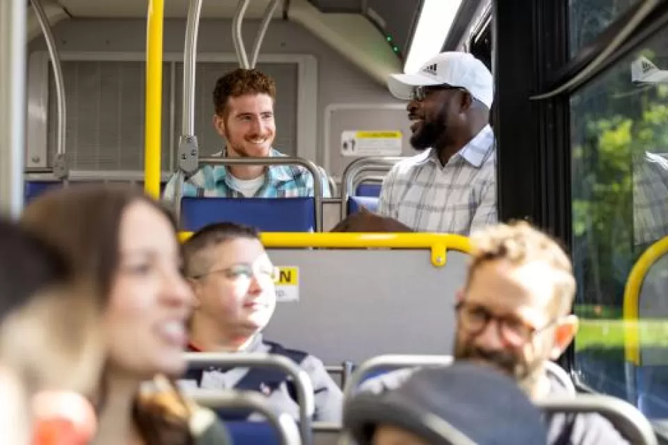 Group of cheery riders inside a CDTA public transit bus.